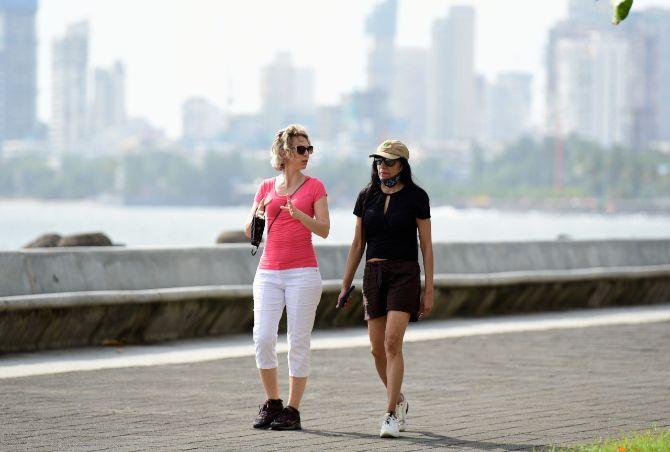 Whether three-ply, plain cloth or even homemade washable ones, the BMC has urged people to wear face mask before venturing out.
In picture: Foreign nationals walking at Marine Drive in South Mumbai