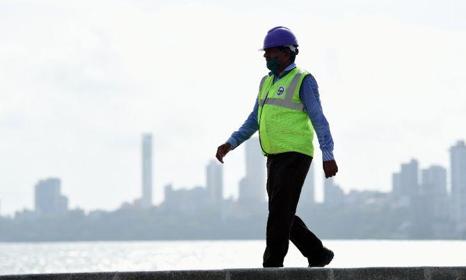 In photo: A construction worker armed with face mask and a helmet was clicked at Marine Drive in South Mumbai.