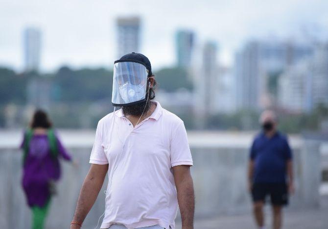 In photo: A man wearing a face mask and a face shield in South Mumbai.