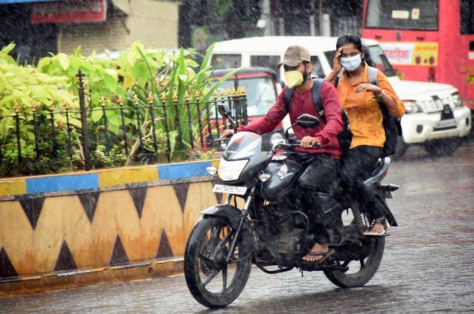 In photo: A biker and pillion rider wearing face masks got drenched as rains hit Mulund.
