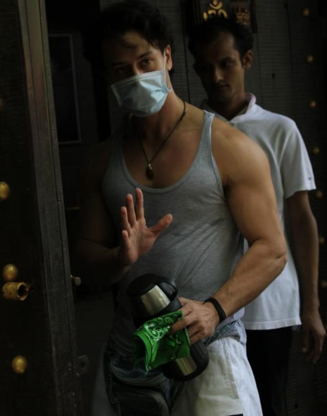 Tiger Shroff was also clicked by the paparazzi at a popular recording studio in Juhu. The actor showed off his ripped body in his grey vest and white pants. He completed his look with a pair of black sneakers and white mask.