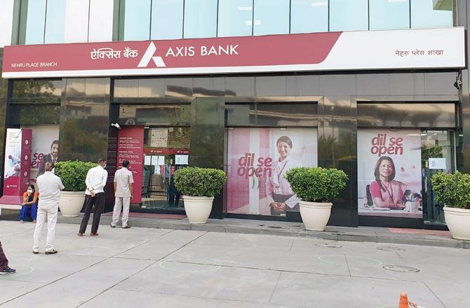 Customers maintain social distancing at an  Axis Bank branch