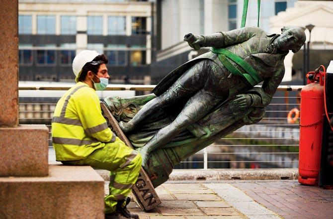 A worker rests after slave owner Robert Milligan’s statue was taken down in the UK.