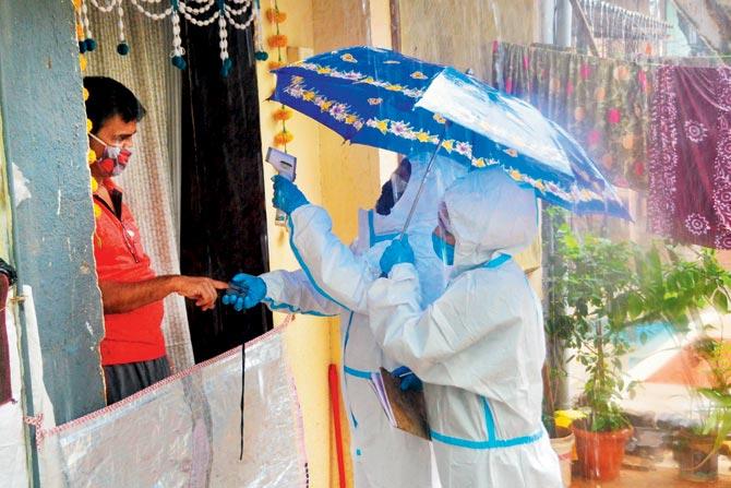Civic health workers conduct door-to-door thermal reading and oximeter checks at Wadia Estate in Kurla West on Thursday. PIC/SAYYED SAMEER ABEDI
