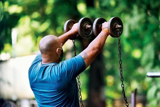 A man is seen lifting weights at an outdoor gym in Matunga. The CDC has pointed out that while touching accessories or surfaces used by others,  “may not be the main way to catch the virus”, it can still put someone at risk. Research on this, is still on.  PIC/PRADEEP DHIVAR