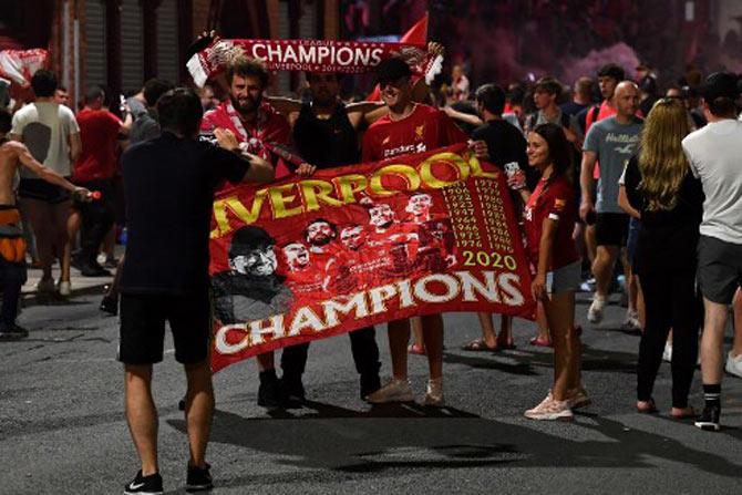 Fans celebrate Liverpool winning the Premier League title outside Anfield stadium in Liverpool, north west England on June 25, 2020, following Chelsea