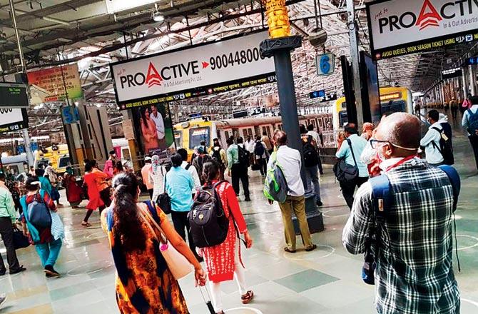 Commuters walk towards local trains at CSMT