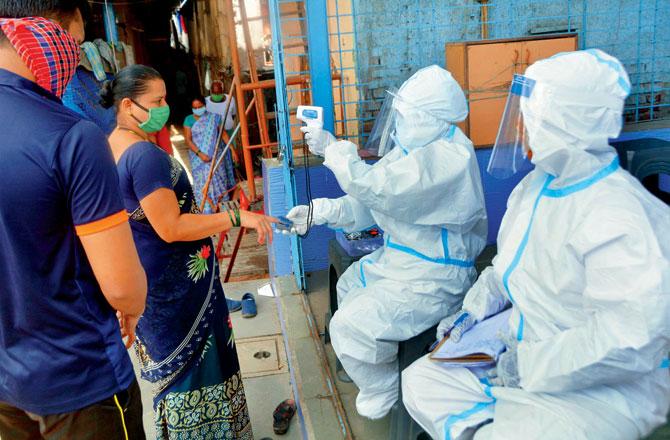 A team of BMC doctors and health workers conduct thermal screening and check-ups at a camp in Kranti Nagar. File pic