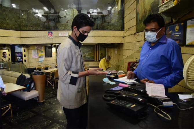 The Maharashtra cyber police warned of strict action against rumour-mongers who are spreading misleading and unverified information on social media regarding COVID-19. The police have stepped up online surveillance in order to identify senders of such fake news and other content.
In photo: Restaurant staff at Dadar TT wear safety mask as they serve customers amidst COVID-19.