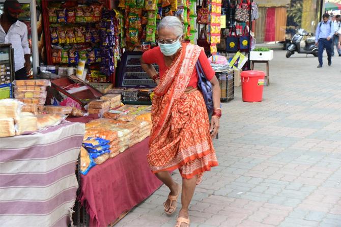 In photo: A senior citizen dons a safety mask amidst the outbreak of coronavirus as she wades through the streets of Dadar.