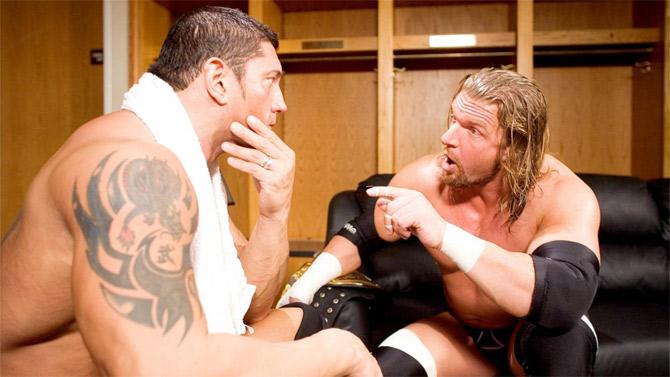 WWE superstars and Evolution members Triple H and Batista discuss a match in the dressing room