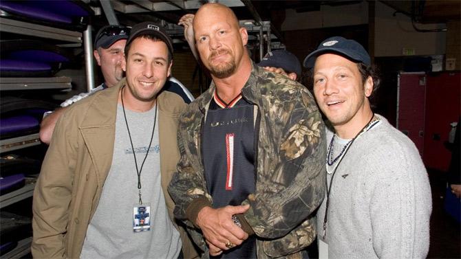 Stone Cold Steve Austin poses backstage with actors Adam Sandler and Rob Schneider.