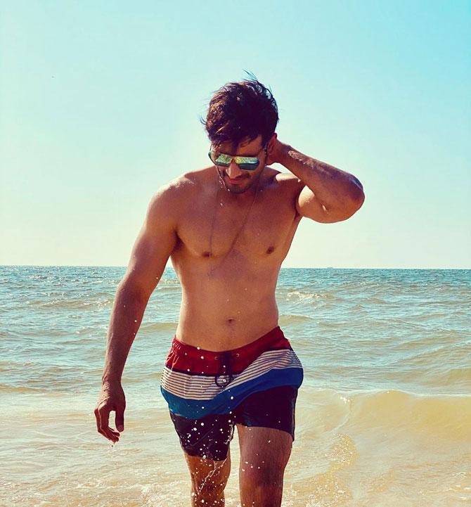 Here's another photo of the hottie flaunting his fit physique in a pair of beach shorts. Now you know why we think Karan's a beach bum!