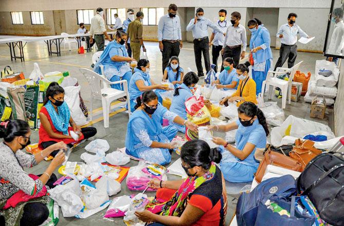 Surat Municipal Corporation members pack food to distribute among the poor in the area on Saturday morning. Pic/PTI