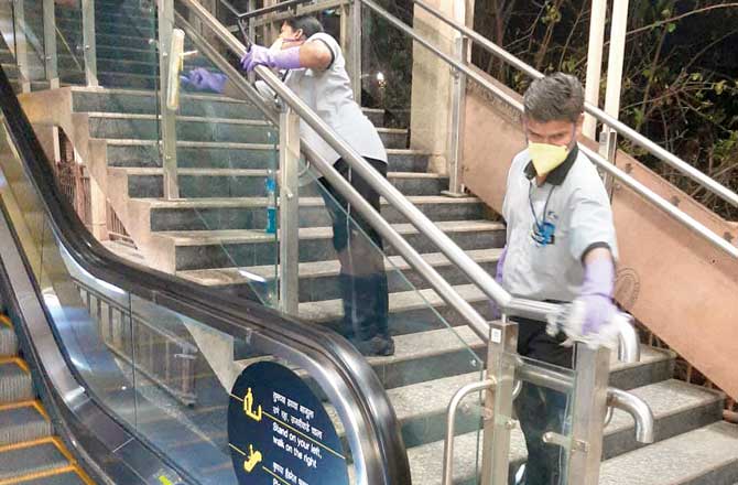 Metro workers disinfect escalators