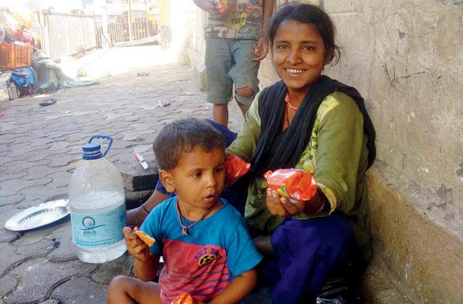 Homeless people with biscuits given to them by members of the Beghar Adhikar Abhiyan