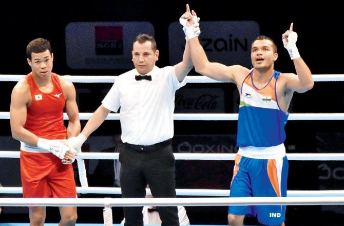 Vikas Krishan (right) celebrates winning the 69kg category bout