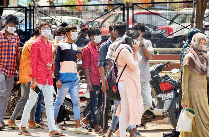 Visitors wear protective masks in the wake of the deadly novel Coronavirus, at Government Gandhi Hospital in Hyderabad. Pic/PTI