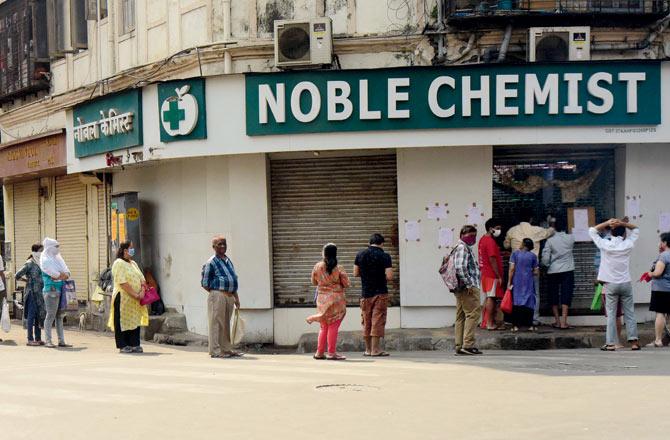 Customers form a queue to buy medicine, at Grant Road, on Wednesday. Pic/Suresh Karkera