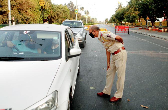 Police officer speaks to a motorist during a nakabandi at Marin Drive. Pic/Ashish Raje