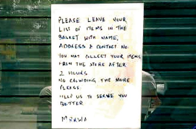 A notice pasted on the door of a shop asks customers to drop a list of provisions they need, which would be home-delivered later