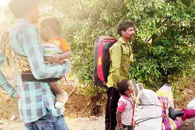 Labourers with luggage leave for their native villages