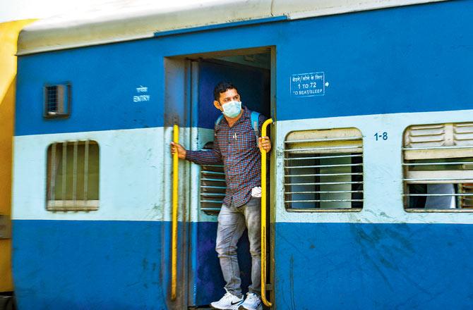 A passenger looks out from a train door during New Delhi’s lockdown on Monday. Pic/PTI