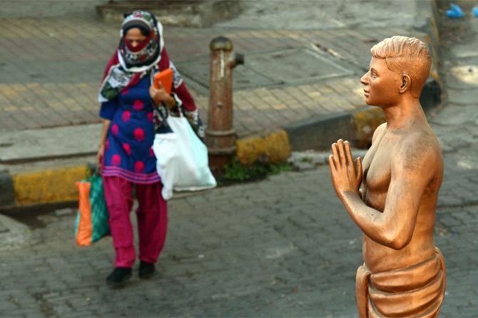 In photo: A woman walks past a sculpture in Goregaon amid lockdown.