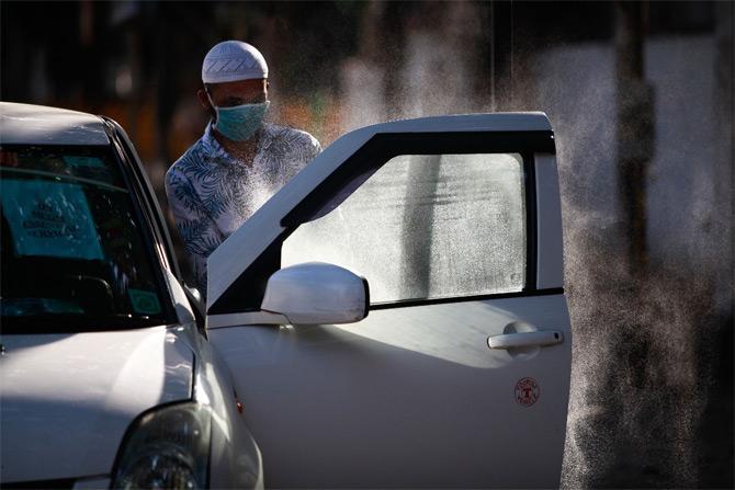 In photo: A driver sanitises his car which has been used by the BMC to battle COVID-19 infection.