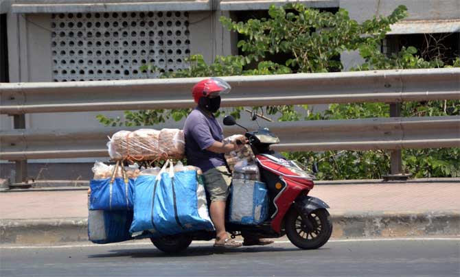 According to the police, at least 194 cases of attacks on policemen were reported in various parts of the state, while 680 persons were arrested in these incidents and 73 policemen and a home guard were injured in these attacks.
In picture: A man rides a scooter on an empty road carrying bags of snacks meant for sale