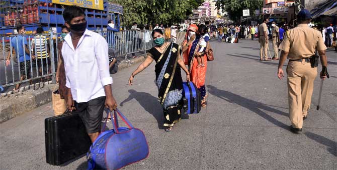 According to the BMC, 650 new suspected patients were admitted to hospitals. Of the 933 new patients, 231 had tested positive as per reports of various labs between May 11 and 12.
In picture: Migrants leaving the city for their hometowns, walk towards a bus stop at Dharavi.