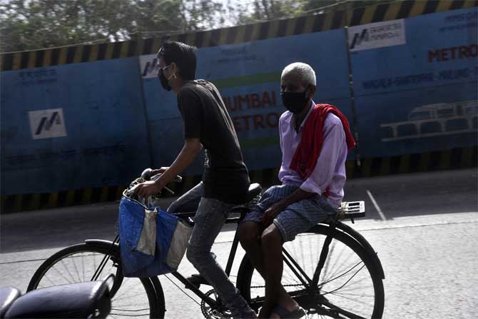 India reported 6,535 new cases of COVID-19 in the last 24 hours, taking the total number of COVID-19 cases in the country to over 1.45 lakh.
In picture: A man ride a bicycle with his father on the back seat in Wadala.