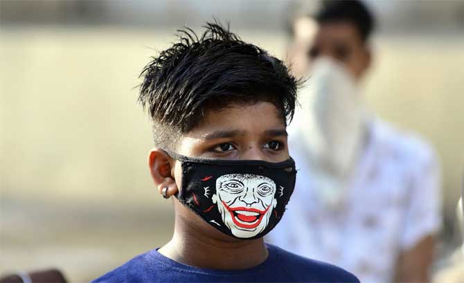 The guidelines state that people with reasons such as pregnancy, death in the family, serious illness, parents accompanied by children below 10 years, a distressful situation, may be permitted home quarantine for 14 days.
In picture: A young boy wears a comic book villain themed mask in Dadar