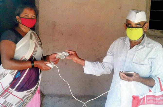 Kavita Kambale withdraws Rs 500 under Pradhan Mantri Garib Kalyan Yojana with the help of postman S M More