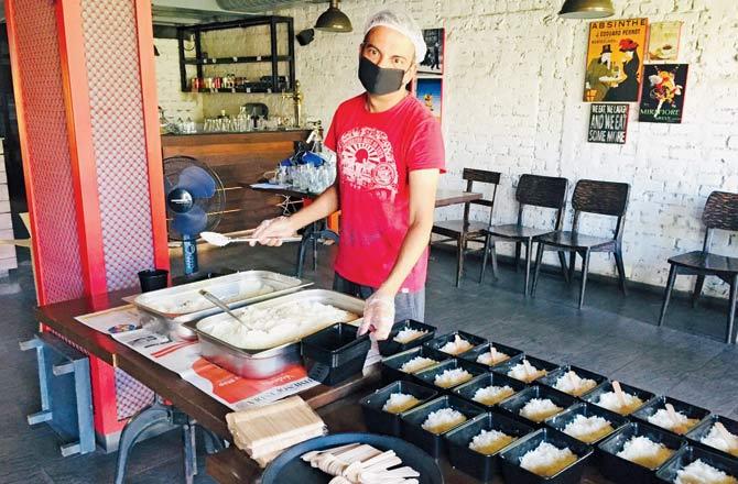 Rohan Saraf, owner of Road House in GK 1, New Delhi, prepares meals for distribution and delivery