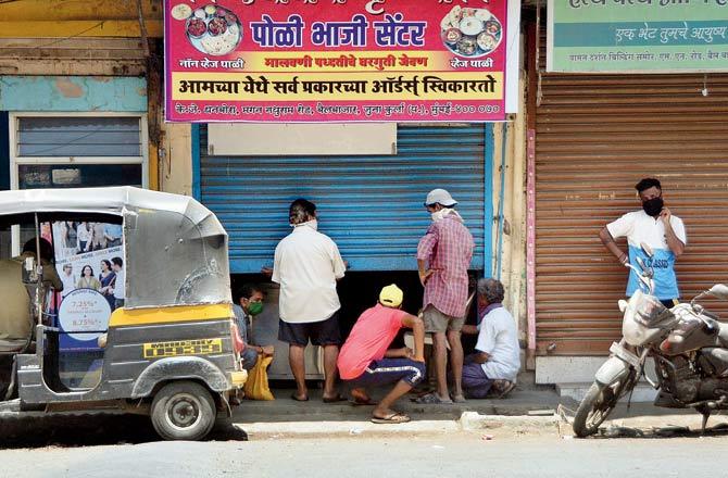 Residents of Kranti Nagar queue up for food parcels outside a hotel along Bailbazar Road on Sunday. Pic/Sayyed Sameer Abedi