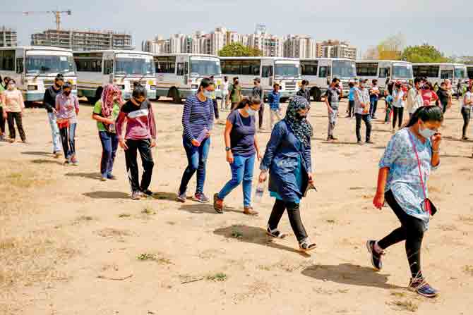 Stranded students from Kota maintain social distance as they walk out of a bus depot upon their arrival in Ahmedabad on April 23. PIC/PTI