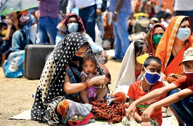 A woman provides shade to her kid with her saree in Suncity
