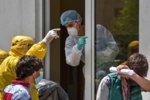 Coronavirus death toll in US crosses one lakh A hospital worker (C) wearing a protective face mask and outfit, speaks with two ambulance doctors wearing yellow protective suits at the Grigor Lusavorich Medical Centre in Yerevan on May 27, 2020, amid the COVID-19 pandemic caused by the novel coronavir