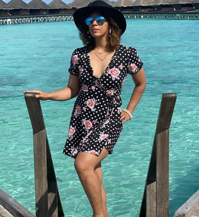 Saina Nehwal seen here a deep neck-cut flowery short dress and a stylish hat as she poses with the ocean as backdrop.
