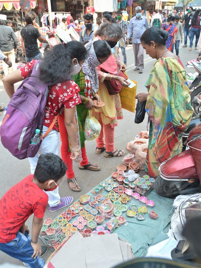 In picture: Women armed with face mask buy diyas from a bazaar in Dadar.