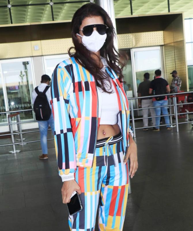 Actress and television presenter Lakshmi Manchu was clicked at the Mumbai Airport. For the outing, the actress opted for a white crop top, multi-coloured jacket, and trousers along with a white mask. A pair of black sunglasses enhanced her look. (All pictures: Yogen Shah).