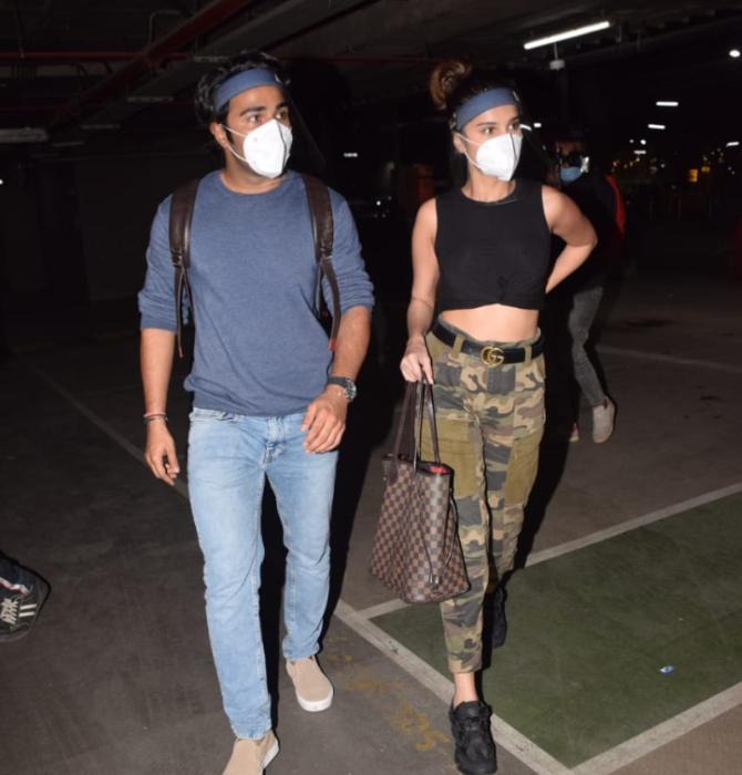 Tara Sutaria and her alleged boyfriend Aadar Jain returned to Mumbai after enjoying a fun-filled vacation in Maldives. The rumoured couple were clicked at the airport together. For the outing, Tara opted for a black crop top and checkered trouser, while Aadar donned a blue t-shirt and denim. The duo wore face masks and shield to prevent the spread of COVID-19. (All pictures: Yogen Shah).