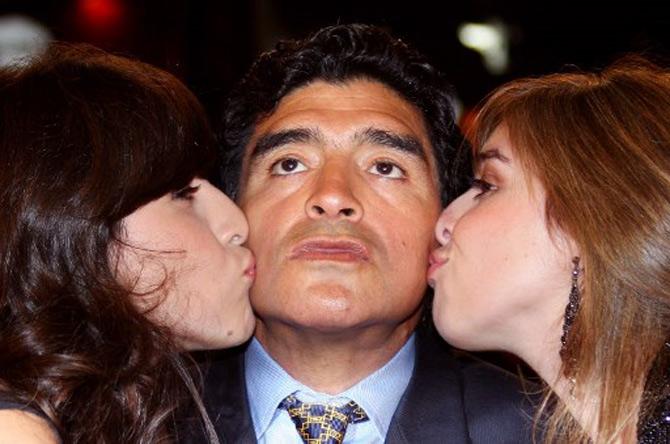 In this file photo taken on May 20, 2008, former Argentinian football player Diego Maradona (C) is kissed by his daughters Giannina (L) and Dalma as he arrives to attend the screening of Serbian director Emir Kusturica's documentary film 'Maradona by Kusturica' at the 61st Cannes International Film Festival in Cannes, southern France.