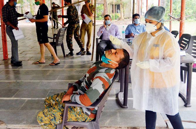 A health worker conducts an antigen test on police personnel (a railway commando) at Ghatkopar East. Pic/Sayyed Sameer Abedi