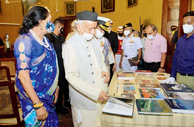 Governor Bhagat Singh Koshyari browses through titles published by the Society in the Durbar Hall