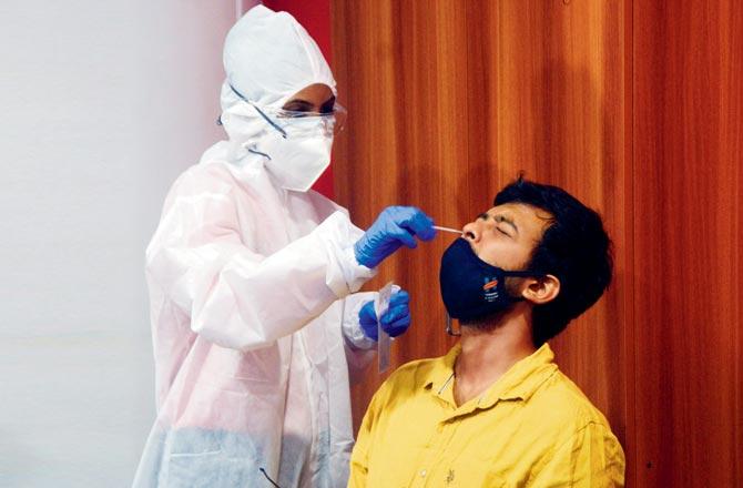 A health worker conducts a swab test at Whistling Woods International institute in Goregaon. File pic