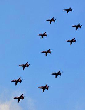 A fleet of fighter jets in the middle of a maneuver.