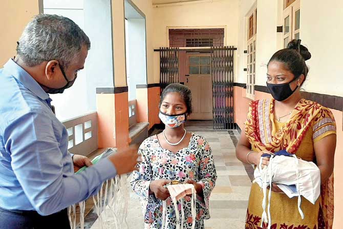 Dr Narayan Iyer, whose NGO started the initiative to help women in distress, distributes masks at schools and to civic staff (right)