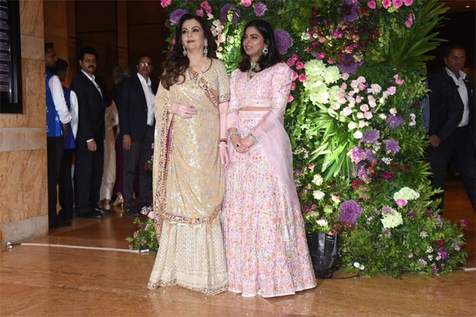 Isha, who walked in with her mother Nita Ambani, donned a pastel pink lehenga and complimented her look with green emerald earrings and minimal makeup.